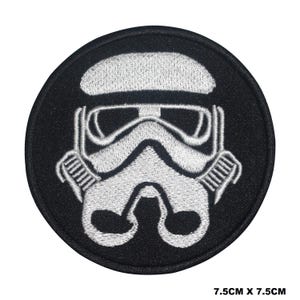 Könnte beinhalten: Ein schwarzer runder Patch mit einem weißen gestickten Stormtrooper-Helm. Der Patch ist 7,5 cm x 7,5 cm groß.