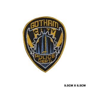 May include: Black and gold embroidered patch with the text "Gotham City Police Dept." and a stylized sword and shield design. The patch is 9.5 cm by 6.5 cm.