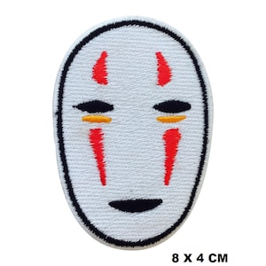 May include: White embroidered patch featuring a mask design with black, red, and yellow accents. The mask has black eye shapes, red vertical lines, and a black curved mouth. The patch measures 8 x 4 cm.