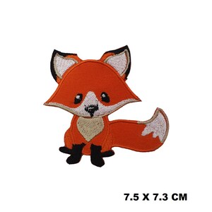 May include: Orange and white embroidered iron-on patch of a cartoon fox with black eyes and a black nose. The patch is 7.5 cm by 7.3 cm.