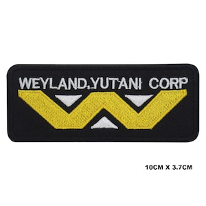 May include: Black embroidered patch with the text "Weyland-Yutani Corp" in white and a yellow stylized "W" logo. The patch measures 10 cm by 3.7 cm.