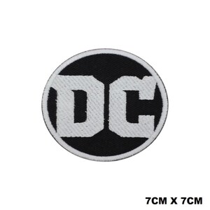 Può includere: Una toppa ricamata in bianco e nero con il logo DC. La toppa è circolare e misura 7 cm x 7 cm.