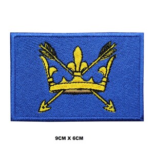 Könnte beinhalten: Ein blauer gestickter Aufnäher mit einer gelben Krone und zwei gekreuzten Pfeilen. Der Aufnäher misst 9 cm x 6 cm.