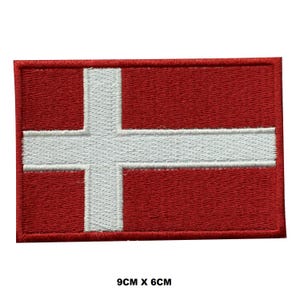 Puede incluir: Un parche bordado de la bandera danesa, con colores rojo y blanco. El parche mide 9 cm por 6 cm.