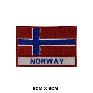 May include: An embroidered patch featuring the Norwegian flag in red, white, and blue, with the word "NORWAY" in white text on a white background. The patch measures 9 cm by 6 cm.