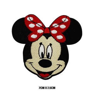 Peut inclure: Patch thermocollant brodé représentant un dessin animé de Minnie Mouse avec son nœud rouge à pois blancs. La taille du patch est de 7 cm par 7,5 cm.