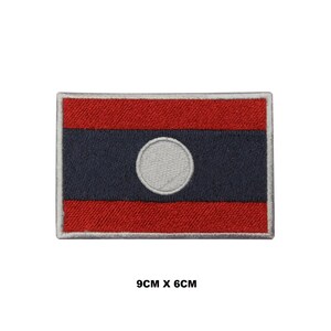May include: Embroidered patch of the Laotian flag. The flag is red with a blue stripe and a white circle in the center. The patch is 9 cm by 6 cm.