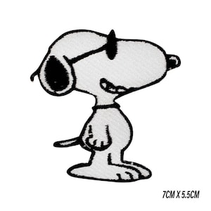 Puede incluir: Parche bordado con Snoopy de Peanuts, de pie. Snoopy es blanco con detalles negros, con gafas de sol. El parche mide 7 cm x 5,5 cm.