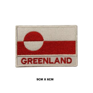 May include: A white and red embroidered patch with the flag of Greenland and the word "GREENLAND" in red lettering. The patch is 9 cm by 6 cm.