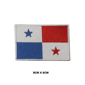 May include: An embroidered patch of the Panamanian flag. The flag is a white rectangle with a blue square in the top left corner, a red rectangle in the top right corner, and a white square in the bottom right corner. There are two blue stars in the blue square and one red star in the white square. The patch is 9 cm by 6 cm.