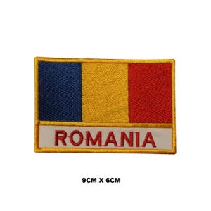 May include: Embroidered patch featuring the Romanian flag with blue, yellow, and red stripes. The patch has a white border with the word "ROMANIA" in red lettering. The patch measures 9 cm by 6 cm.