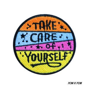 May include: A circular embroidered patch with the text "TAKE CARE OF YOURSELF" in black. The design features horizontal stripes of orange, light blue, and pink. The patch measures 7cm x 7cm and has a yellow border.