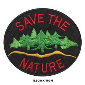 Puede incluir: Un parche circular negro con texto bordado en rojo que dice "SAVE THE NATURE" y una imagen bordada en verde de una fila de pinos con una línea bordada en oro debajo. El parche mide 8,5 cm por 10 cm.