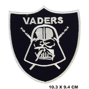 May include: Black and white embroidered patch featuring a Darth Vader helmet design with the text "VADERS" above it. The patch is shaped like a shield and has a white outline. It measures 10.3 x 9.4 cm.