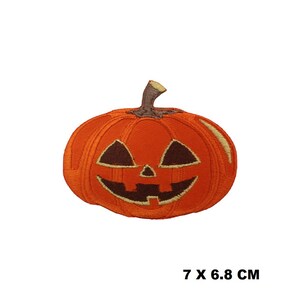 May include: Orange embroidered Halloween pumpkin patch with a carved jack-o'-lantern face. The patch is 7 by 6.8 centimeters.