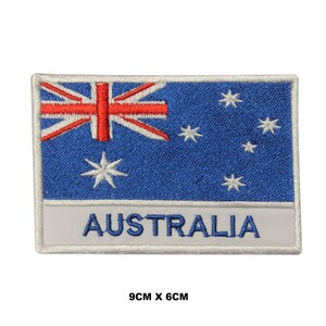 Pode incluir: Patch bordado com a bandeira australiana. O design apresenta um fundo azul com estrelas brancas e a Union Jack no canto superior esquerdo. A palavra "AUSTRALIA" é exibida em branco em uma faixa branca. Mede 9 cm x 6 cm.
