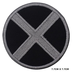 May include: A black and gray embroidered patch with a large X in the center. The patch is circular and measures 7.7 inches in diameter.