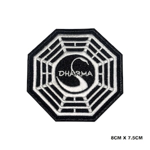 Puede incluir: Parche bordado en blanco y negro con el logotipo de la Iniciativa Dharma. El logotipo es un cisne blanco dentro de un octógono negro con la palabra "DHARMA" escrita en blanco.