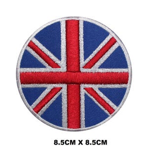 Puede incluir: Un parche redondo bordado con la bandera del Reino Unido en rojo, blanco y azul. El parche tiene un diámetro de 8,5 cm.