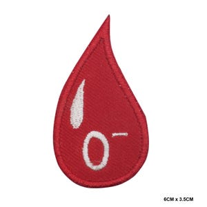 Puede incluir: Parche bordado con forma de gota de sangre roja con la letra 'O-' en blanco. El parche mide 6 cm por 3,5 cm.