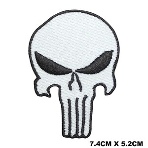 May include: White embroidered skull patch with black eyes and a skull outline. The patch measures 7.4 cm by 5.2 cm.