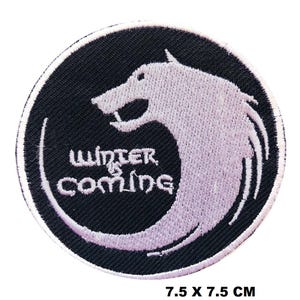Könnte beinhalten: Runder, schwarzer, gestickter Aufnäher mit einem weißen Wolfsdesign und dem Text "Winter is Coming". Der Aufnäher misst 7,5 x 7,5 cm.