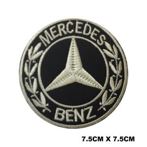 May include: Circular embroidered patch with the Mercedes-Benz logo. The patch is black with a white star emblem, encircled by a laurel wreath and the words "MERCEDES" and "BENZ". The patch measures 7.5cm x 7.5cm.