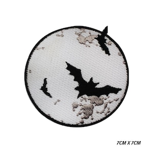 May include: Embroidered patch with a black bat design against a white, textured moon. The patch is round with a black border. The dimensions are 7cm x 7cm.