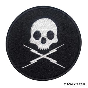 Puede incluir: Un parche bordado en blanco y negro con un diseño de calavera y huesos cruzados. La calavera es blanca con ojos negros y una nariz negra. Los huesos cruzados son blancos y están cruzados detrás de la calavera. El parche tiene un diámetro de 7,2 cm.