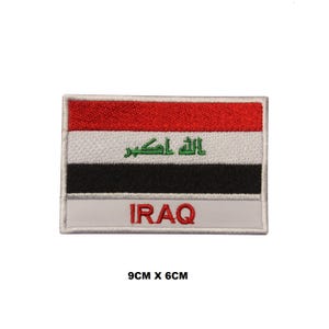 May include: An embroidered patch featuring the flag of Iraq. The patch is white with a red, white, black, and green Iraqi flag in the center. The words "IRAQ" are written in red below the flag. The patch measures 9 cm by 6 cm.