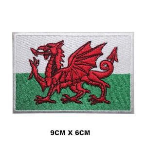 Può includere: Una toppa ricamata con la bandiera del Galles. La toppa è bianca con un drago rosso su sfondo verde. Il drago è rivolto a destra e ha le ali spiegate. La toppa misura 9 cm per 6 cm.