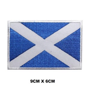 Pode incluir: Um remendo bordado da bandeira da Escócia. A bandeira é azul com uma cruz branca. O remendo mede 9 cm por 6 cm.