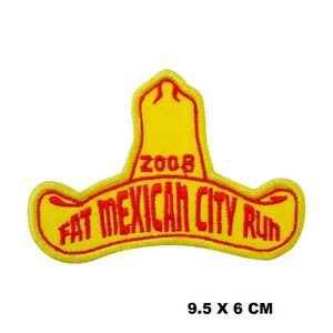 May include: Yellow felt patch with red embroidered text that reads "2008 Fat Mexican City Run". The patch is shaped like a sombrero.