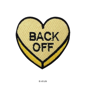 May include: Yellow heart-shaped embroidered patch with black stitching and the text "BACK OFF" in black.