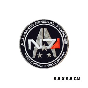 May include: A black and white embroidered patch with the text "Alliance Special Forces Training Program" and the letters "N7" in white with a red accent. The patch is 9.5 inches by 9.5 inches.