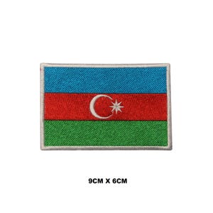 May include: Embroidered patch of the Azerbaijani flag. The flag is blue, red, and green with a white crescent moon and star in the center. The patch is 9 inches by 6 inches.