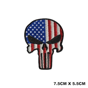 May include: An embroidered iron-on patch featuring a skull with the American flag design. The skull is red, white, and blue. The patch is 7.5 cm by 5.5 cm.