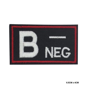 May include: Black embroidered patch with white lettering that reads "B-NEG" with a red border. The patch is 6.5 cm by 4 cm.