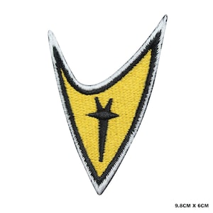 Op de afbeelding: Gele geborduurde Starfleet-insignia patch met een zwarte omtrek en een zwart-wit symbool in het midden. De patch is 9,8 cm bij 6 cm.