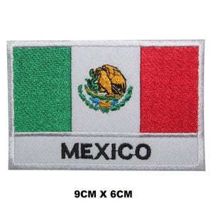 May include: An embroidered iron-on patch featuring the Mexican flag with the coat of arms in the centre. The patch is white with green, white, and red stripes and the word "MEXICO" in black lettering. The patch measures 9 cm by 6 cm.