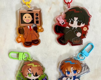 May include: Four acrylic keychains featuring chibi-style characters. One has a television head, one a dark-haired figure with a rabbit, one a green-eyed character with an eyepatch, and one a blue-eyed character holding a large blade.
