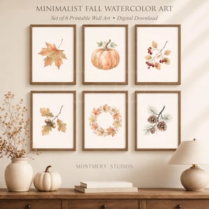 Könnte beinhalten: Ein Set aus sechs gerahmten Aquarelldrucken mit herbstlichen Motiven wie einem Ahornblatt, einem Kürbis, roten Beeren, Eicheln, einem Blattkranz und Tannenzapfen. Der Text lautet MINIMALIST FALL WATERCOLOR ART, Set of 6 Printable Wall Art, Digital Download und MONTMERY STUDIOS.