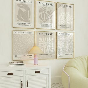 Set of 12 beige Henri Matisse inspired posters featuring abstract botanical shapes, geometric floral forms, and modern cut-out style designs. This neutral boho art collection uses soft beige tones and minimalist lines, making it ideal for a modern gallery wall, or mid-century modern home decor. Elegant abstract flowers and geometric modern art prints create a cohesive, calm aesthetic for living rooms, bedrooms, and stylish interiors.