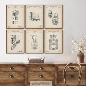 Set of 12 vintage photography patent prints featuring classic camera designs, Polaroid patent art, tripod, flash, lens, and film cartridge illustrations. Perfect wall art for photographers, photography studios, camera collectors, or office decor. Ideal gift for photography lovers, film enthusiasts, or vintage blueprint print collectors. Great for gallery walls, creative spaces, and retro home decor themes.