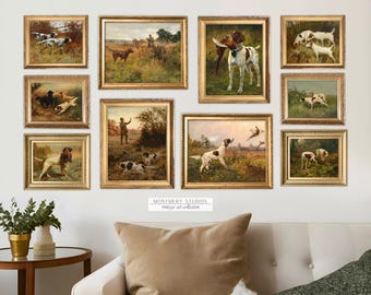 May include: A collection of nine framed paintings depicting hunting dogs in various poses. The paintings are all in gold frames and are arranged in a grid pattern on a white wall. The paintings are all in a similar style and feature realistic depictions of the dogs.