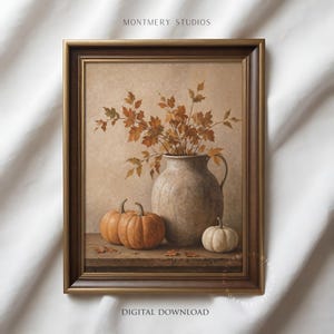 Muted pumpkin still life printable wall art, featuring orange pumpkins, a white pumpkin, rustic ceramic vase, and dried autumn leaves on a wooden table. Warm neutral fall painting for farmhouse decor, Thanksgiving wall art, fall kitchen print, mantel styling, rustic autumn decor, and cozy seasonal home decor.