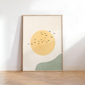 May include: A minimalist art print featuring a large yellow sun with a flock of black birds flying above it. A green hill is in the foreground.
