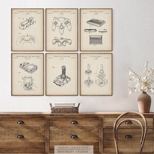 Set of 12 vintage video game blueprint prints featuring game controllers, handheld consoles, cartridges, and TV gaming systems. Ideal for gamer wall art, man cave gaming setups, retro gaming prints, and Father's Day gamer gifts. Blueprint-style decor perfect for classic game room decoration and nostalgic tech lovers.
