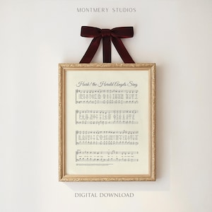 May include: Framed print of sheet music with the text "Hark! the Herald Angels Sing." The print is in a gold-colored frame and is suspended by a burgundy ribbon. The words "MONTEMERY STUDIOS" and "DIGITAL DOWNLOAD" are also visible.
