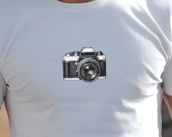 May include: A white t-shirt with a black and white illustration of a vintage camera.